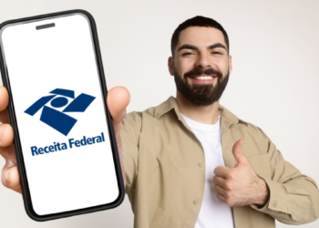 Jovem exibe aplicativo da Receita Federal em celular com expressão positiva.
