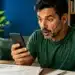 Homem acompanhando investimentos do Tesouro Direto pelo celular em ambiente doméstico