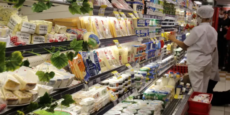 Gôndola de supermercado com alimentos refrigerados durante fiscalização sobre normas de publicidade de alimentos revisadas pela Anvisa.
