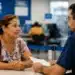 Senhora brasileira recebe atendimento presencial de servidor do INSS em agência da Previdência Social, representando a ação especial com mais de 12 mil vagas.