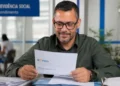 Homem consulta documento de recurso do INSS em uma agência de atendimento.