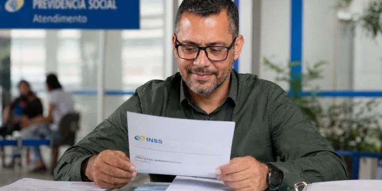 Homem consulta documento de recurso do INSS em uma agência de atendimento.