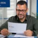 Homem consulta documento de recurso do INSS em uma agência de atendimento.
