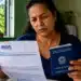 Mulher analisa documento do INSS segurando carteira de trabalho para entender regras de benefícios sem carência