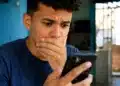 Jovem reage ao celular após bloqueio de acesso a plataformas de apostas