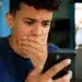 Jovem reage ao celular após bloqueio de acesso a plataformas de apostas