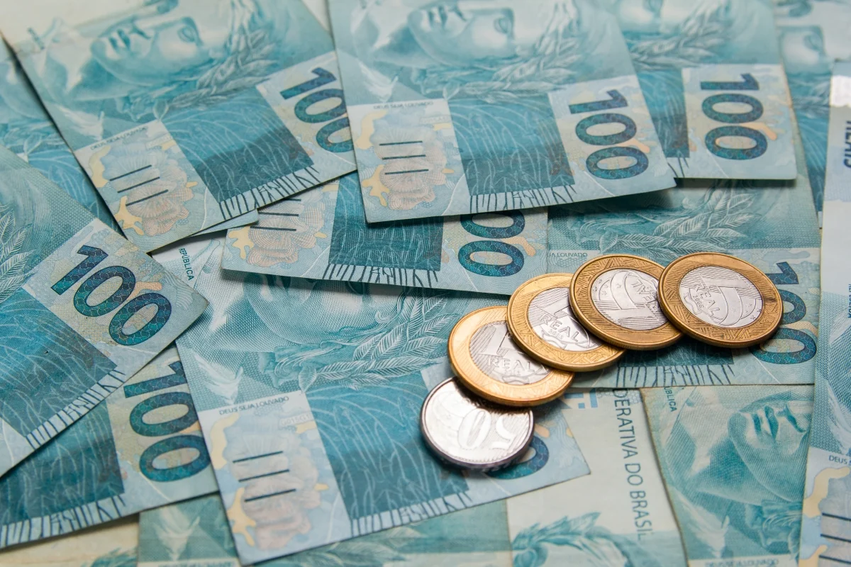 Cédulas e moedas de real ilustram o cálculo do reajuste do salário mínimo