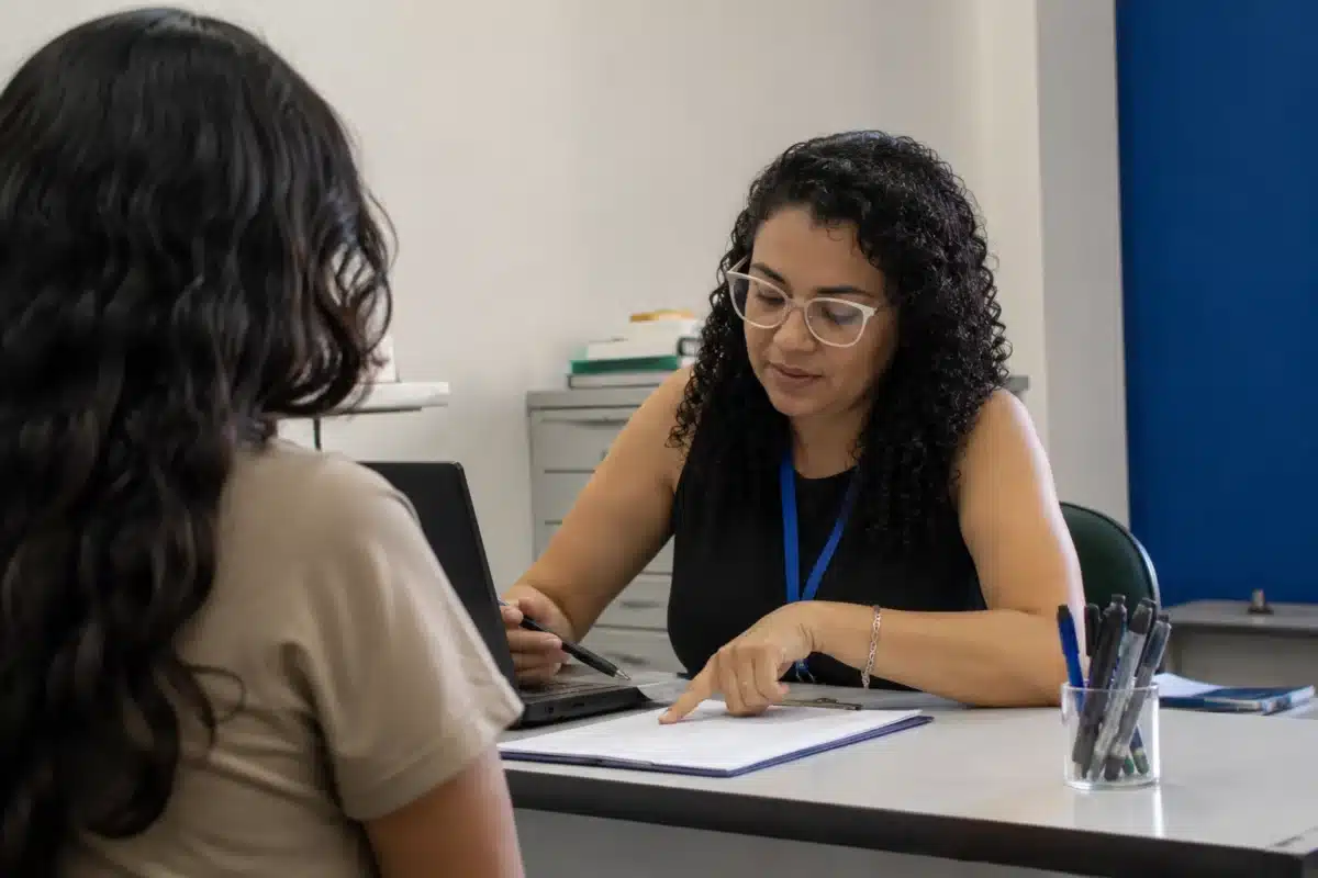 Certificação após a divulgação do resultado do Encceja Participante recebendo orientações de uma atendente sobre a solicitação do certificado após o Encceja.