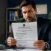 Homem segurando documento de CNPJ alfanumérico emitido pela Receita Federal em novo modelo de identificação empresarial