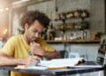 Imagem ilustrativa de jovem estudando deitada no chão diante do notebook, cercada de livros, ao lado da expressão Concurso Público.