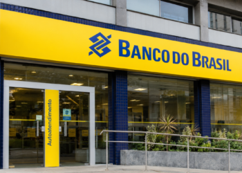 Fachada de agência do Banco do Brasil com logotipo em destaque, ilustrando informações sobre o concurso da instituição em 2026.