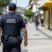 Guarda municipal fardado patrulha rua de cidade durante ação de segurança pública.