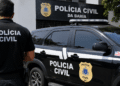 Viatura e agente da Polícia Civil da Bahia em frente à unidade policial.