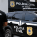 Viatura e agente da Polícia Civil da Bahia em frente à unidade policial.