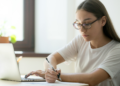 Candidata estuda em frente ao notebook para concursos públicos com inscrições abertas no DF e na Bahia.