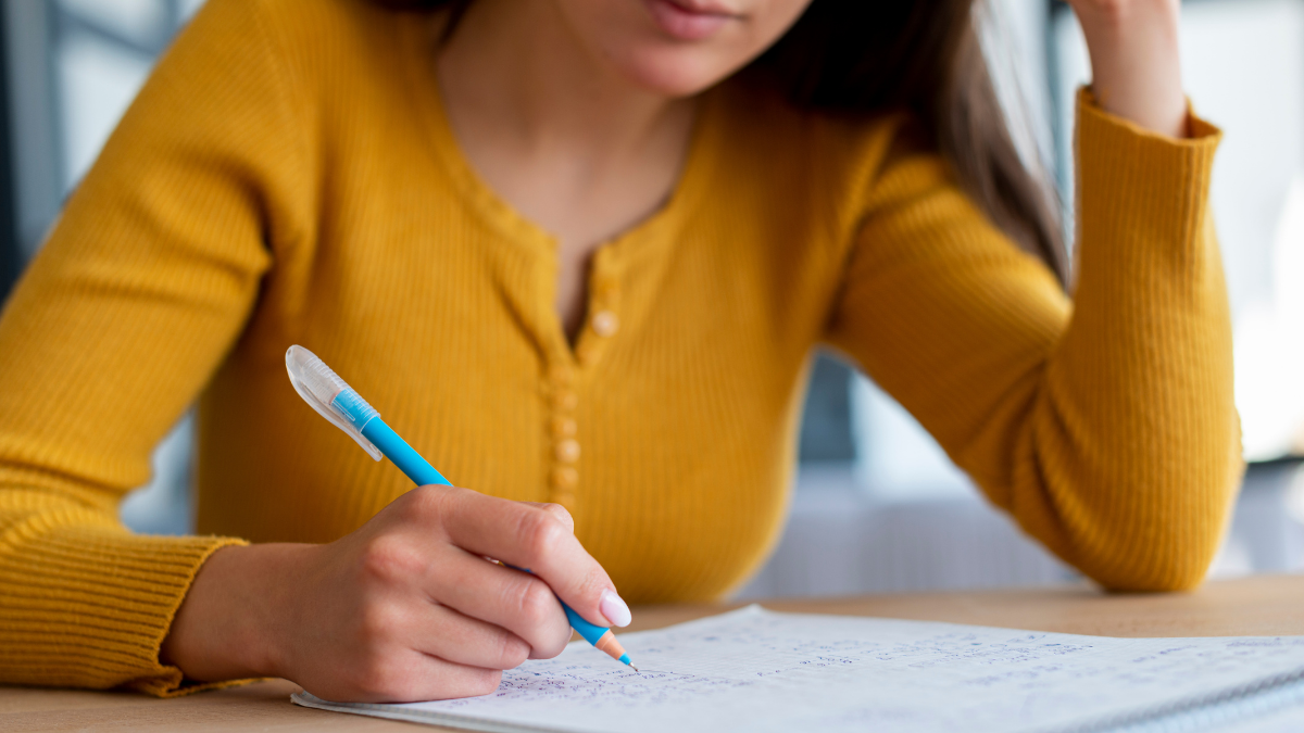 Pessoa estudando para concurso público com caderno e caneta, representando preparação para seleções com vagas abertas.