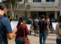 Candidatos consultam informações de concurso público em frente à Câmara Municipal durante período de inscrições.