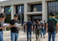 Candidatos caminham em direção a uma Câmara Municipal com mochilas, documentos e materiais de estudo para concurso público.