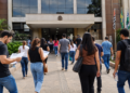 Pessoas se dirigindo a prédio público para representar concursos das Câmaras Municipais com inscrições abertas.