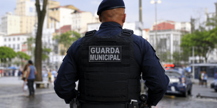 Guarda Municipal de costas durante patrulhamento em área urbana.