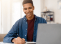 Estudante consultando informações no computador representa candidatos acompanhando novos concursos públicos com inscrições abertas.
