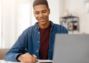 Estudante consultando informações no computador representa candidatos acompanhando novos concursos públicos com inscrições abertas.
