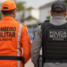 Bombeiro Militar e policial militar de Alagoas de costas, representando mudanças nos concursos da PM e dos Bombeiros.