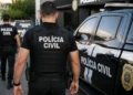 Policiais civis uniformizados ao lado de viatura oficial da Polícia Civil durante ação operacional.