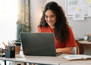 Mulher consulta informações sobre concursos municipais pelo notebook.