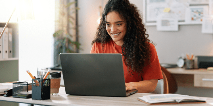 Mulher consulta informações sobre concursos municipais pelo notebook.