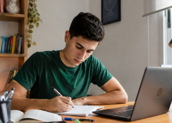 Candidato estuda com notebook e faz anotações para provas de concursos públicos em Minas Gerais.