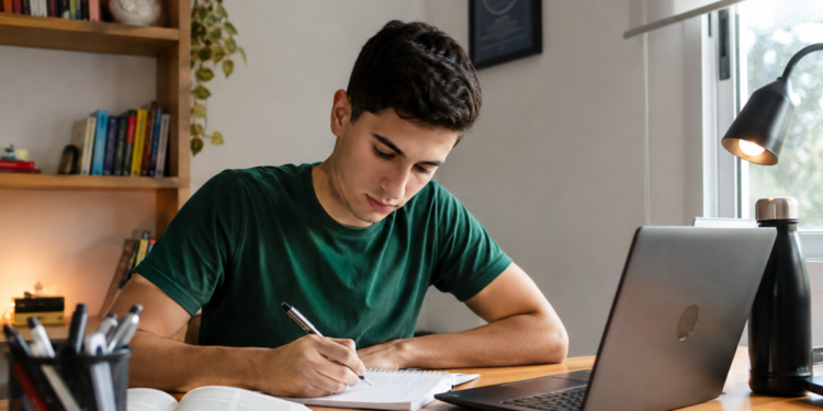 Candidato estuda com notebook e faz anotações para provas de concursos públicos em Minas Gerais.
