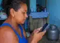 Mulher consulta pelo celular informações sobre o vale-recarga do programa Gás do Povo