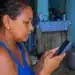 Mulher consulta pelo celular informações sobre o vale-recarga do programa Gás do Povo