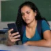 Estudante consulta informações sobre o pagamento do programa Pé-de-Meia pelo celular em sala de aula