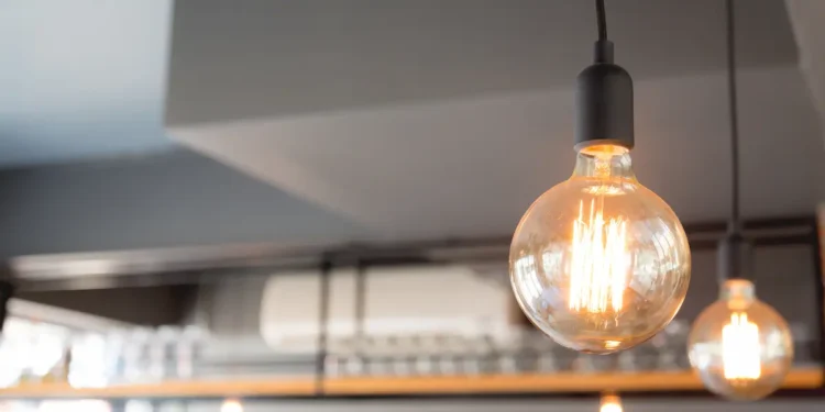Lâmpada acesa representando o consumo de energia elétrica e os fatores que influenciam o valor da conta de luz.
