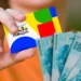 Mão segura cartão do Bolsa Família ao lado de cédulas de real, em referência à continuidade dos pagamentos do programa.