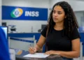Estagiária preenche formulário em uma unidade do INSS para iniciar contribuição previdenciária.