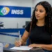 Estagiária preenche formulário em uma unidade do INSS para iniciar contribuição previdenciária.
