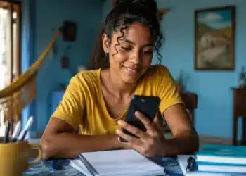 Estudante acompanha pelo celular informações sobre a convocação da lista de espera do Fies 2026.