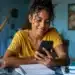 Estudante acompanha pelo celular informações sobre a convocação da lista de espera do Fies 2026.