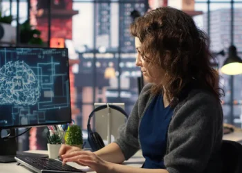 Mulher acompanha curso de inteligência artificial em computador, representando a capacitação online gratuita oferecida pelo Serpro.