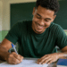 Jovem participa de atividade de capacitação em sala de aula com material de estudo.