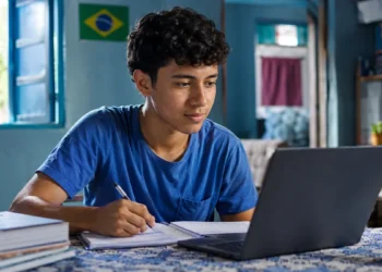 Estudante brasileiro estudando em casa com notebook e caderno para cursos gratuitos em 2026