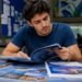 Estudante analisa materiais de pós-graduação para escolher uma especialização.