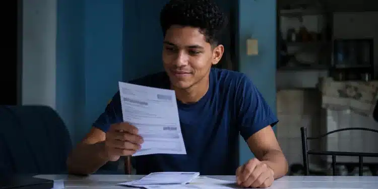 Estudante analisa documentos representando o desconto na dívida do Fies pelo Desenrola Adimplentes.