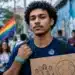 Jovem segura cartaz sobre cidadania em espaço urbano durante representação do Dia Nacional dos Direitos Humanos.