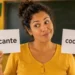 Professora segura cartões com as palavras “crocante” e “cocrante” em sala de aula.