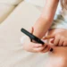 Criança utilizando smartphone em casa, representando a proteção de menores nos serviços digitais.