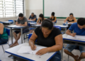 Participantes fazem a prova do Encceja em sala de aula de escola pública.